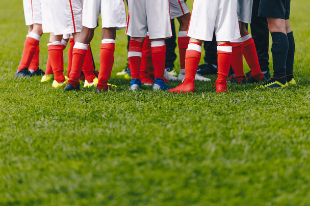 Ομάδα ποδοσφαίρου Λυκείου που στέκεται στην ομάδα. Ποδόσφαιρο γρασίδι χωράφι και τα πόδια των παικτών - Φωτογραφία, εικόνα