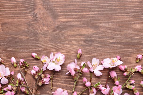 Beautiful blossoming branches on wooden background - Foto, imagen
