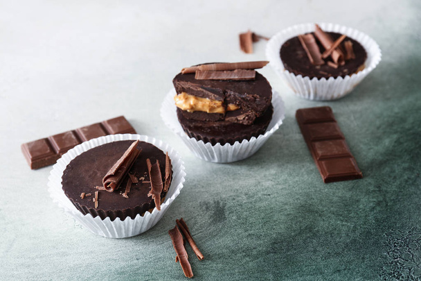 Tasty chocolate peanut butter cups on color background - Foto, immagini