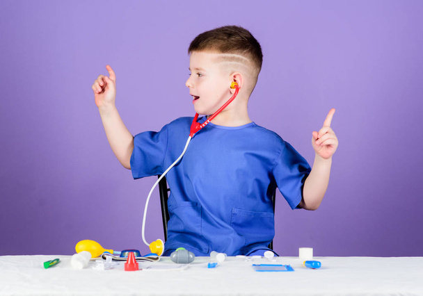 Medicine concept. Health care. Medical examination. Medical education. Play game. Boy cute child future doctor career. Healthy life. Kid little doctor sit table with stethoscope and medical tools - Zdjęcie, obraz