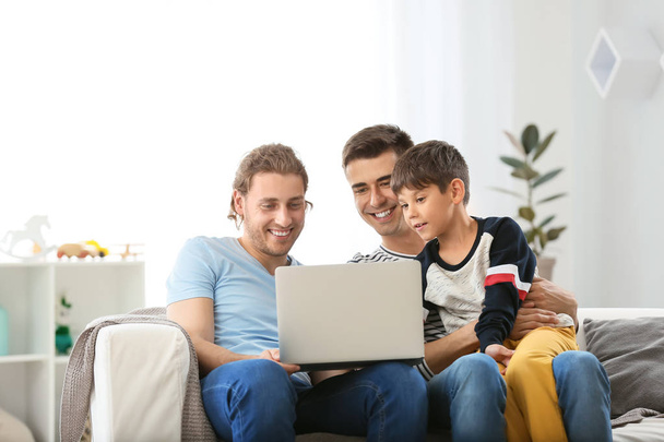 glückliches homosexuelles Paar und Adoptivkind mit Laptop zu Hause - Foto, Bild