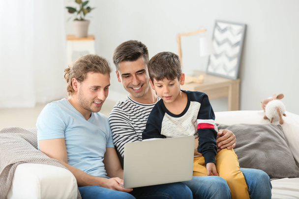 Szczęśliwy homoseksualista para i adoptowany dziecko z laptop w Dom - Zdjęcie, obraz