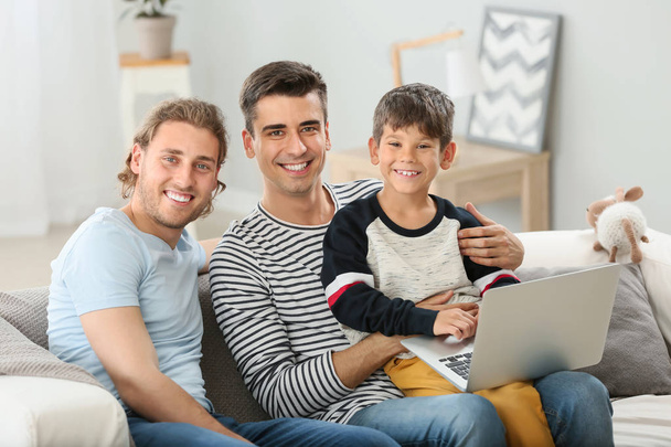 Mutlu eşcinsel çift ve evde dizüstü bilgisayar ile evlat lık çocuk - Fotoğraf, Görsel