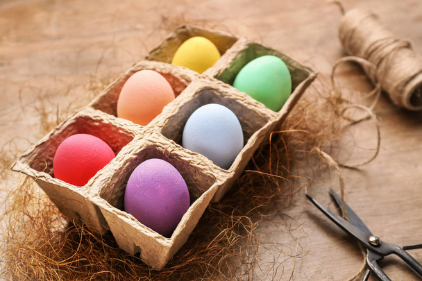 Пакет з красивими великодніми яйцями на дерев'яному фоні
 - Фото, зображення