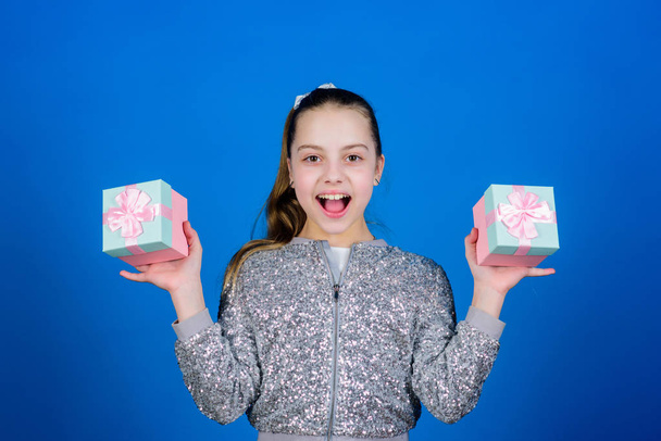 Black friday. Shopping day. Cute child carry gift boxes. Surprise gift box. Birthday wish list. World of happiness. Pick bonus. Special happens every day. Girl with gift boxes blue background - 写真・画像