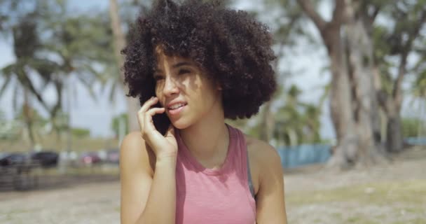 Content ethnic woman speaking on phone - Filmati, video