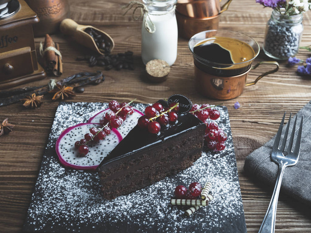 Čokoládový Mozartův dort, červený rybíz na stole šálek kávy, smetana - Fotografie, Obrázek