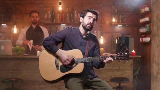 Yakışıklı adam akustik gitar tutkuyla bir şarkı performans - Video, Çekim