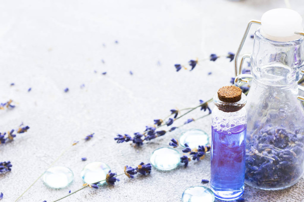 Spa and wellness setting with lavender flowers, sea salt, oil in a bottle, aroma candle on wooden white background - 写真・画像