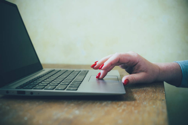 Žena ruka s červenými nehty na klávesnici notebooku, dáma pomocí notebooku na staré retro stůl - Fotografie, Obrázek