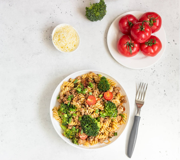 Pasta with meat sauce, cherry tomatoes and broccoli. Mediterranean cuisine with pasta ingredients - olive oil, broccoli and tomatoes. - Фото, зображення