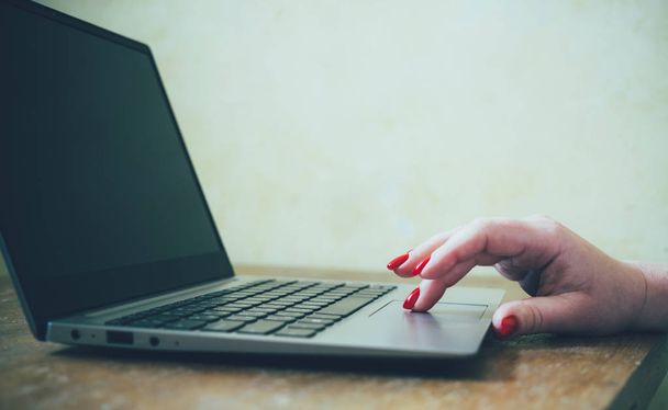 Mão das mulheres com unhas vermelhas no teclado do laptop, senhora usando laptop na velha mesa vintage
 - Foto, Imagem