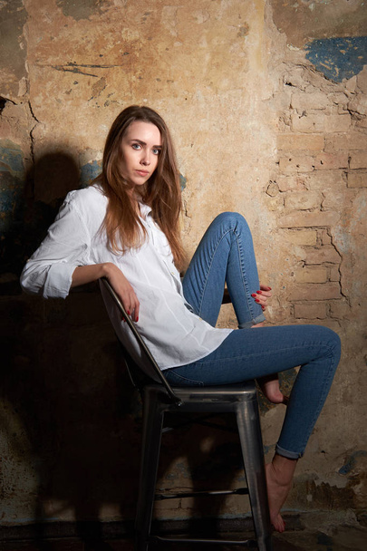 Young attractive girl or model wearing a white shirt siting on t - Foto, imagen