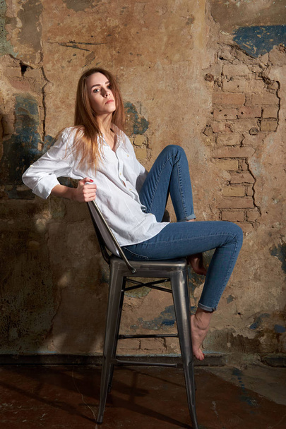 Jovem menina atraente ou modelo vestindo uma camisa branca situada em t
 - Foto, Imagem