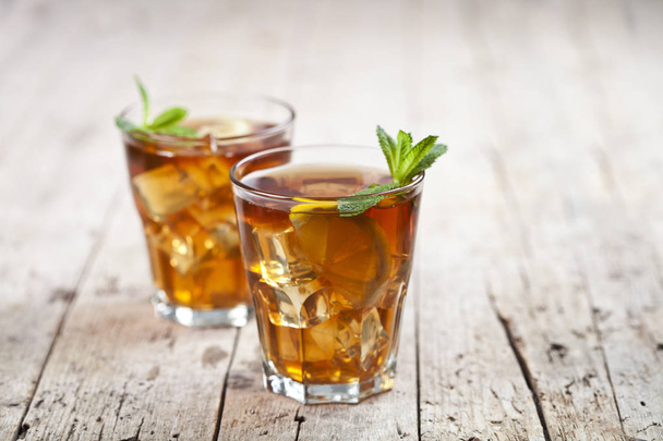 Two glasses with traditional iced tea with lemon, mint leaves an - Foto, Bild