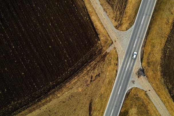Aerial view of single white car on road through countryside - Foto, afbeelding