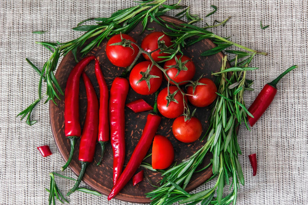 Fresh cherry tomatoes, sprigs of rosemary and chili peppers on a - Foto, Imagem