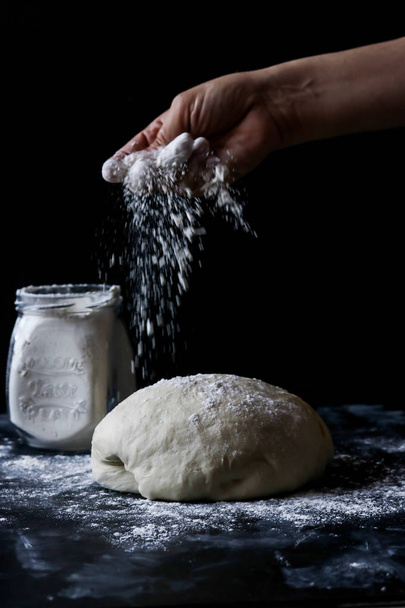 Dough flour on a black background - Fotoğraf, Görsel