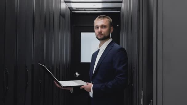 Portrait visage d'ingénieur informatique avec ordinateur portable dans la salle de serveur du datacenter
 - Séquence, vidéo