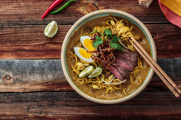 Boiled noodles, beef steak, egg, onion in a bowl, asian cuisine, copy space. - Photo, Image