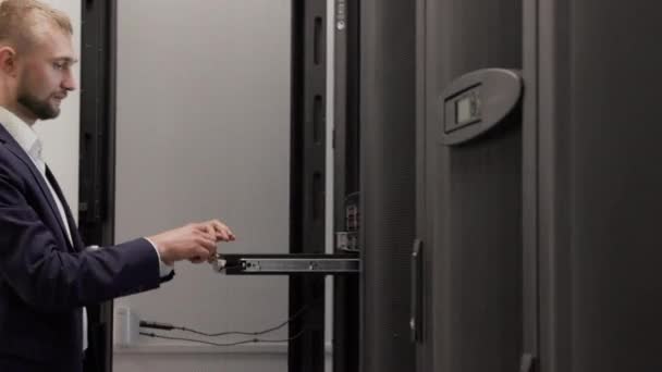 Serverový inženýr pracující v místnosti datových Center pomocí přenosného počítače - Záběry, video