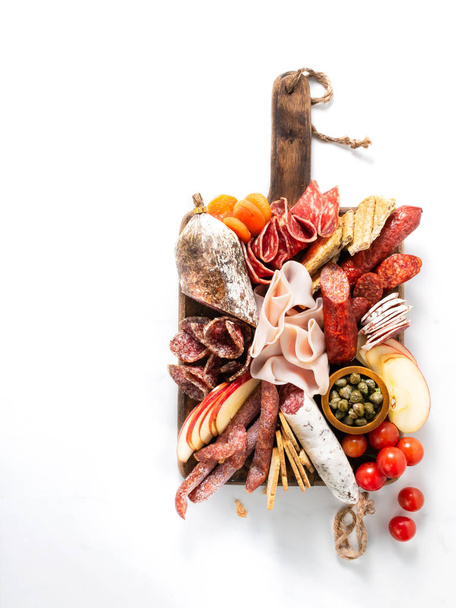 Cold meat plate, charcuterie on white background with copy space. Traditional Spanish tapas selection - chorizo, salchichon, jamon serrano, lomo, salami. - 写真・画像