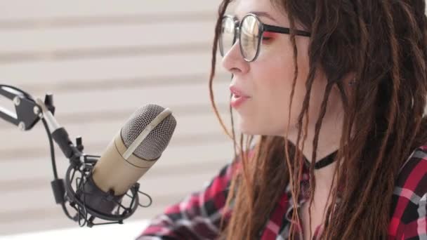 Streaming- und Sendekonzept. junges fröhliches Mädchen im Studio spricht ins Mikrofon - Filmmaterial, Video
