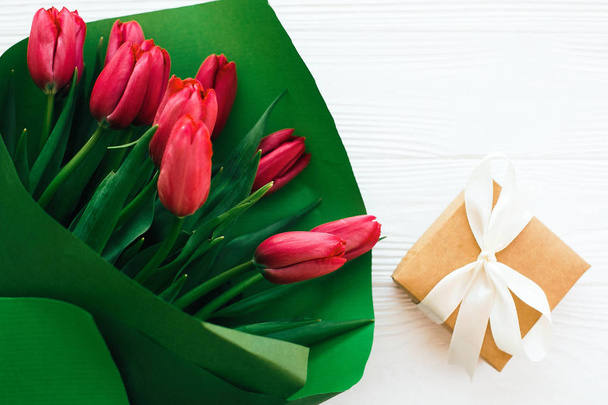 Bellissimo bouquet di tulipani rossi in carta verde e confezione regalo su cui
 - Foto, immagini