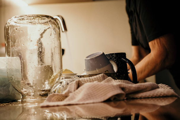 Washed glass jar stands in front of sink. - Fotó, kép