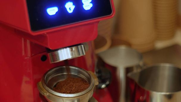Elektrický mlýnek na kávu mele čerstvě pražená kávová zrna do držáku filtru - Fotografie, Obrázek