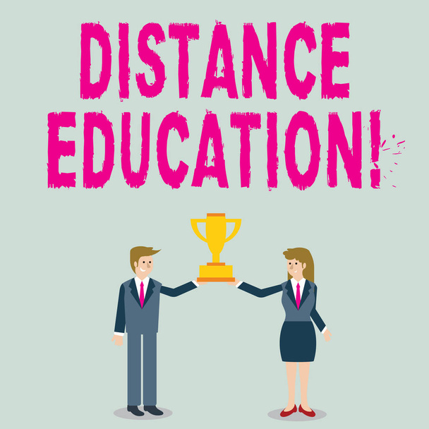 Word writing text Distance Education. Business concept for learning remotely without being present at school Man and Woman in Business Suit Holding Together the Championship Trophy Cup. - Photo, image