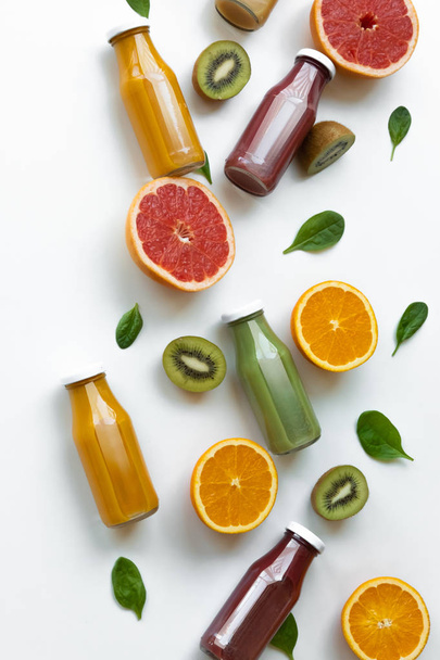 Healthy concept. Oranges, grapefruits, kiwi and juices on yellow background. - Fotografie, Obrázek