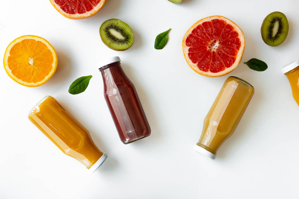 Fondo saludable con diferentes jugos y frutas en escritorio blanco
 - Foto, Imagen