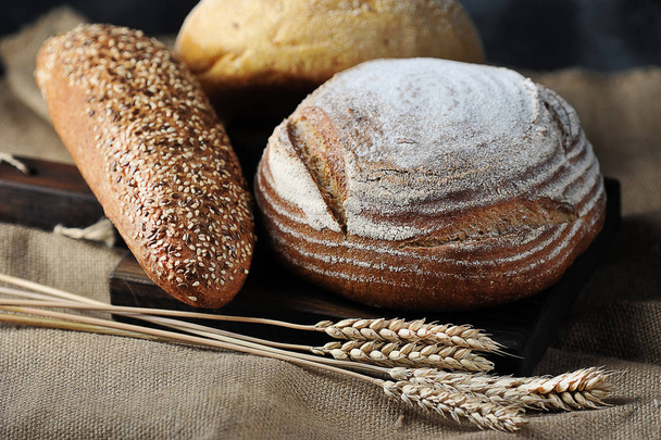 bread and grain ears on burlap - Фото, зображення