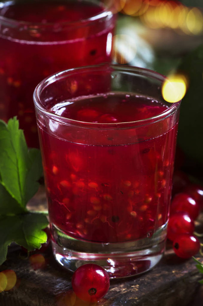 Red currant cocktail with juice, vodka and lime on dark table, top view - Фото, изображение