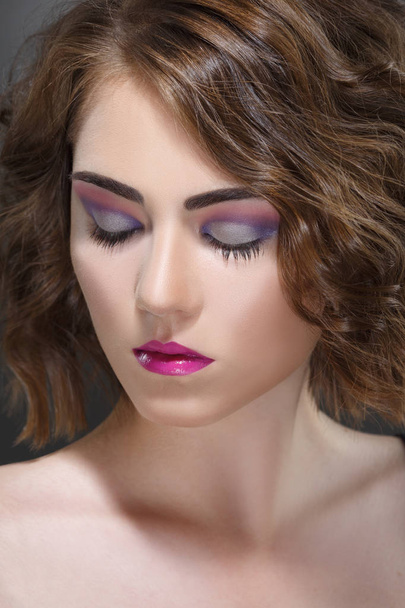 Divat szépség portréja egy lány egy fényes make-up a lila hangok. - Fotó, kép