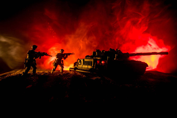 Концепция войны. Военные силуэты боевой сцены на фоне тумана войны, силуэт бронированного автомобиля под облачным горизонтом ночью. Сцена нападения. Танковая битва. Декорации
 - Фото, изображение