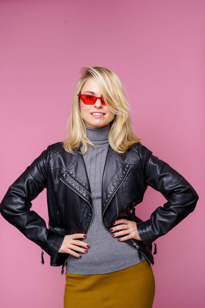 Image of happy blonde woman in pink glasses and black leather jacket - Foto, Imagen