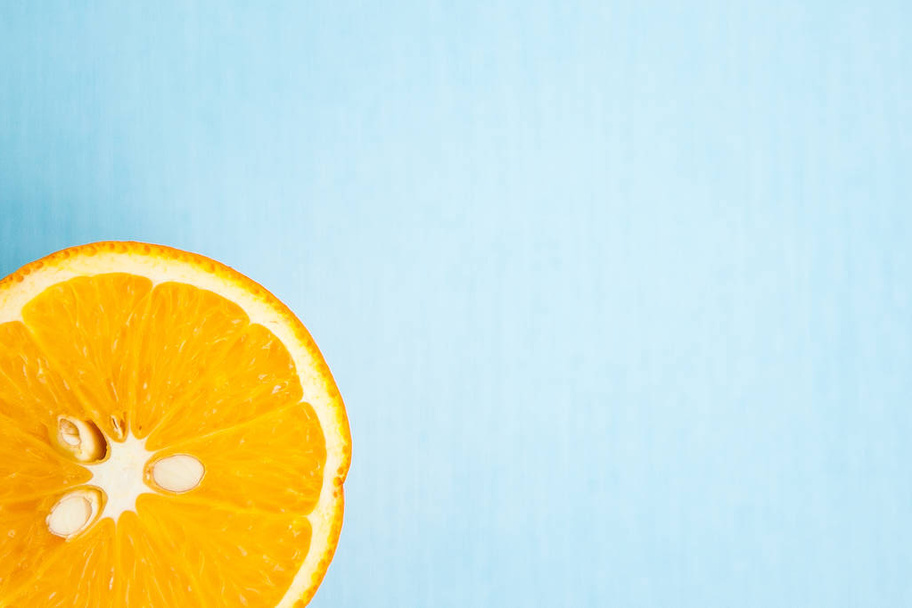 Half of orange on light blue background - Foto, Imagen