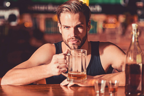 He is a big fan of beer. Addicting to alcoholic drink. Alcohol addict with beer mug. Man drinker in pub. Handsome man drink beer at bar counter. Beer restaurant. Alcohol addiction and bad habit - Фото, зображення