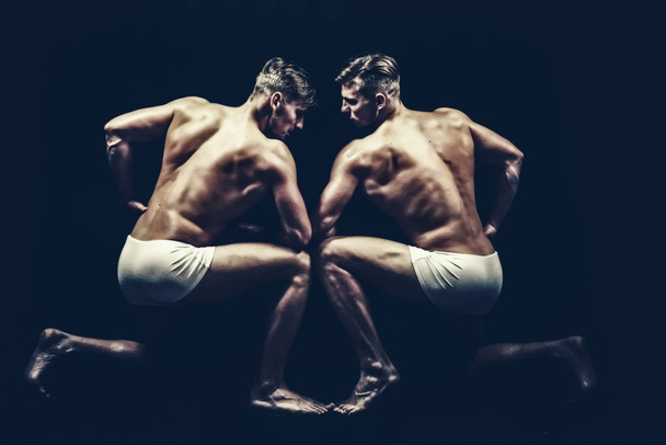 Sport workout for bodybuilder. Fitness dieting and flexibility in acrobatics. Twins men with muscular body in pose. Friendship of men do gymnastic. Circus gymnasts at pilates or yoga training - Fotoğraf, Görsel