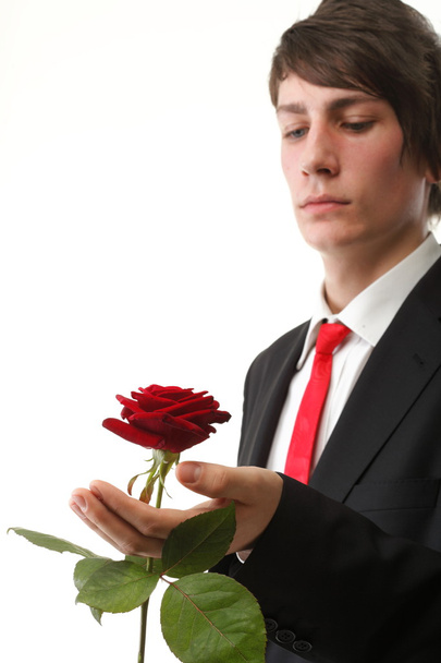 Young man presenting a flower red rose isolated - Foto, Bild