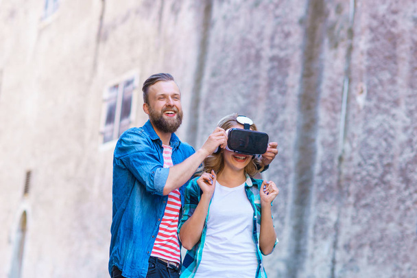 Couple walking in the street in augmented or virtual reality headset. VR, AR, entertainment devices and futuristic technology concept. - Valokuva, kuva