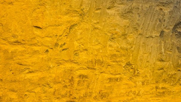 Golden stone surface texture. Natural background in gold color. Texture of stone wall in retro style. Widescreen - Foto, Bild