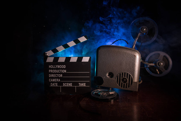 Antiguo proyector de películas vintage sobre un fondo oscuro con niebla y luz. Concepto de realización de películas. Enfoque selectivo
 - Foto, Imagen