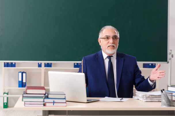 Profesor varón envejecido frente a pizarra
  - Foto, imagen