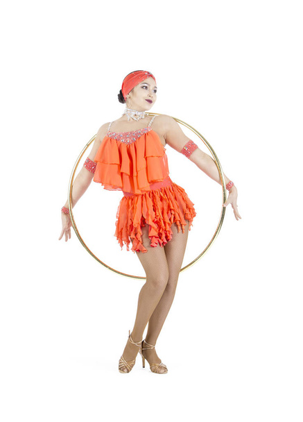 A girl in a stage dress performs a dance with a hula Hoop. - Fotografie, Obrázek