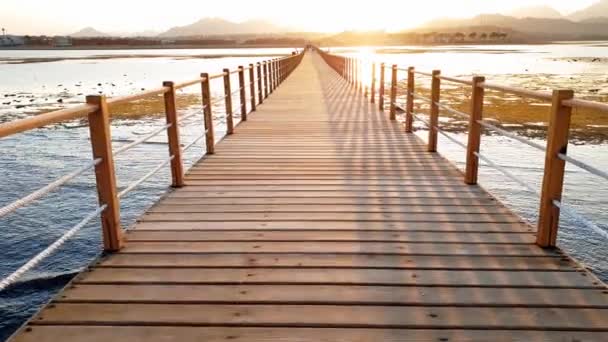 4k videó gyönyörű naplemente az óceán és a hosszú, fából készült mólón - Felvétel, videó