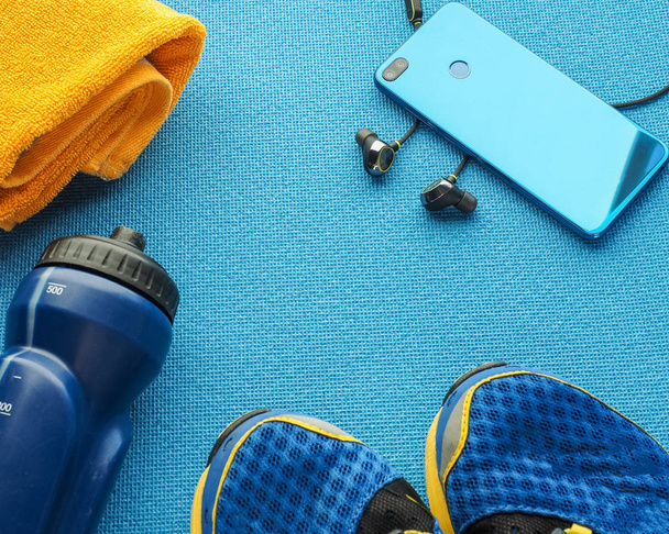 Sports equipment flat lay composition, running shoes, yellow tow - Foto, imagen