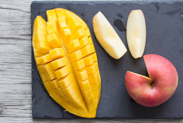 Siyah taş tabakta mango ve elma - Fotoğraf, Görsel